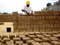 Nidal Eid builds his home with mud bricks